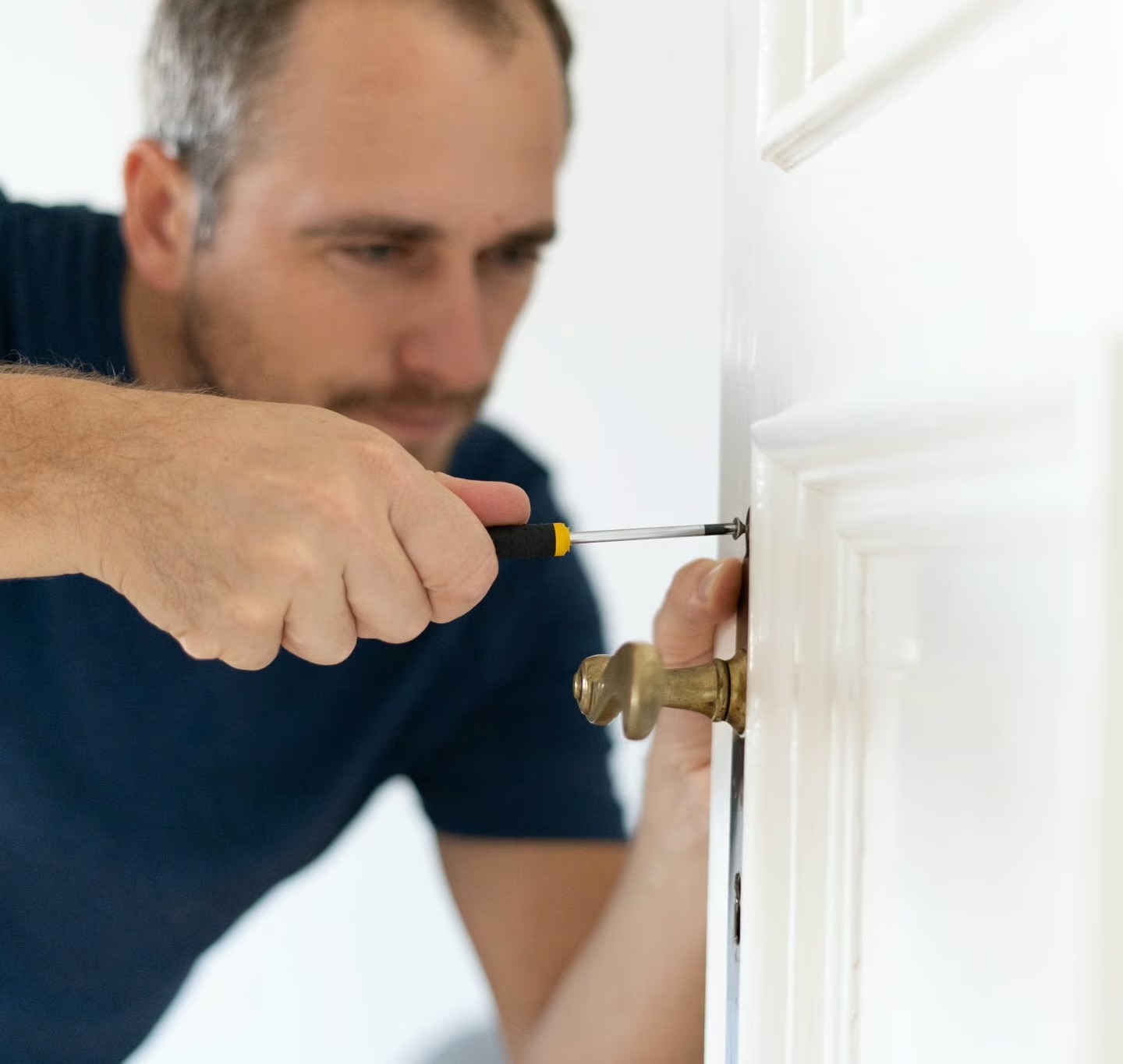 Handyman fitting a door handle in a Berlin apartment
